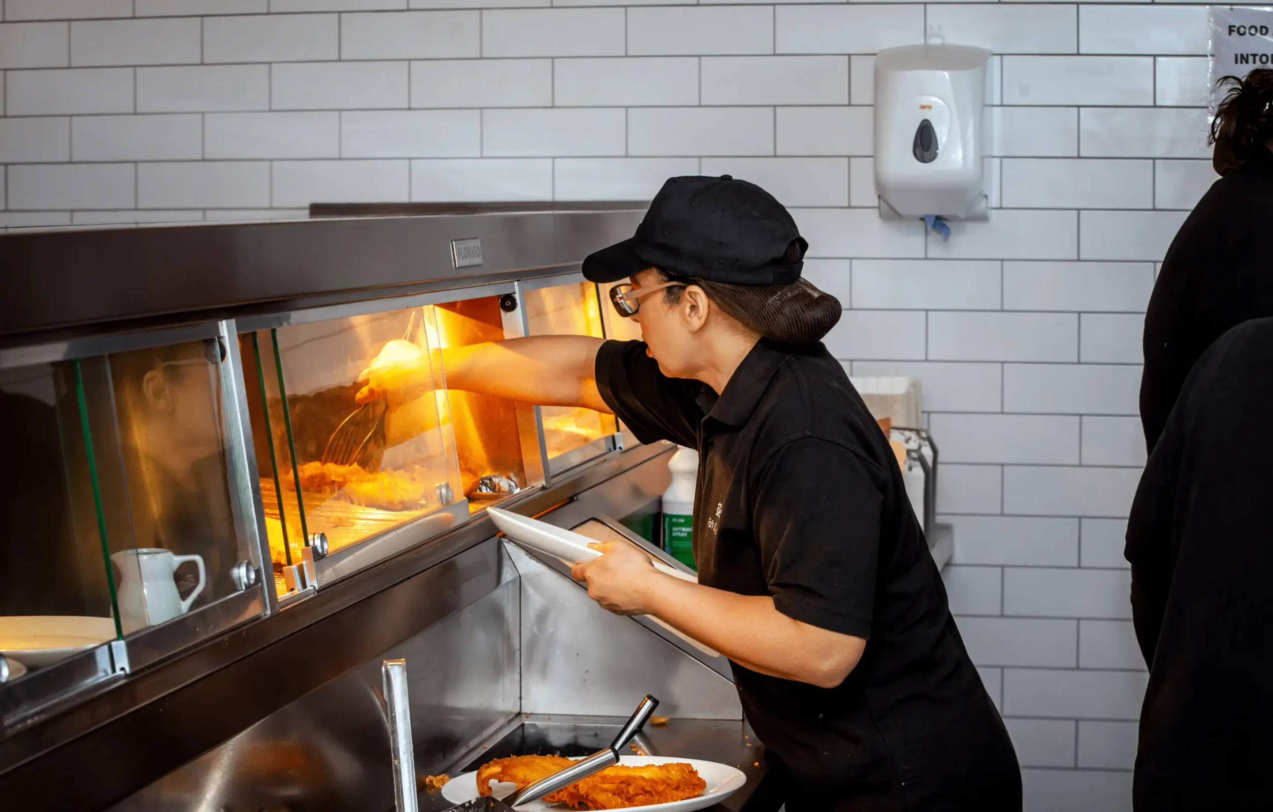 Woman serving fish fresh out of Florigo Frying range