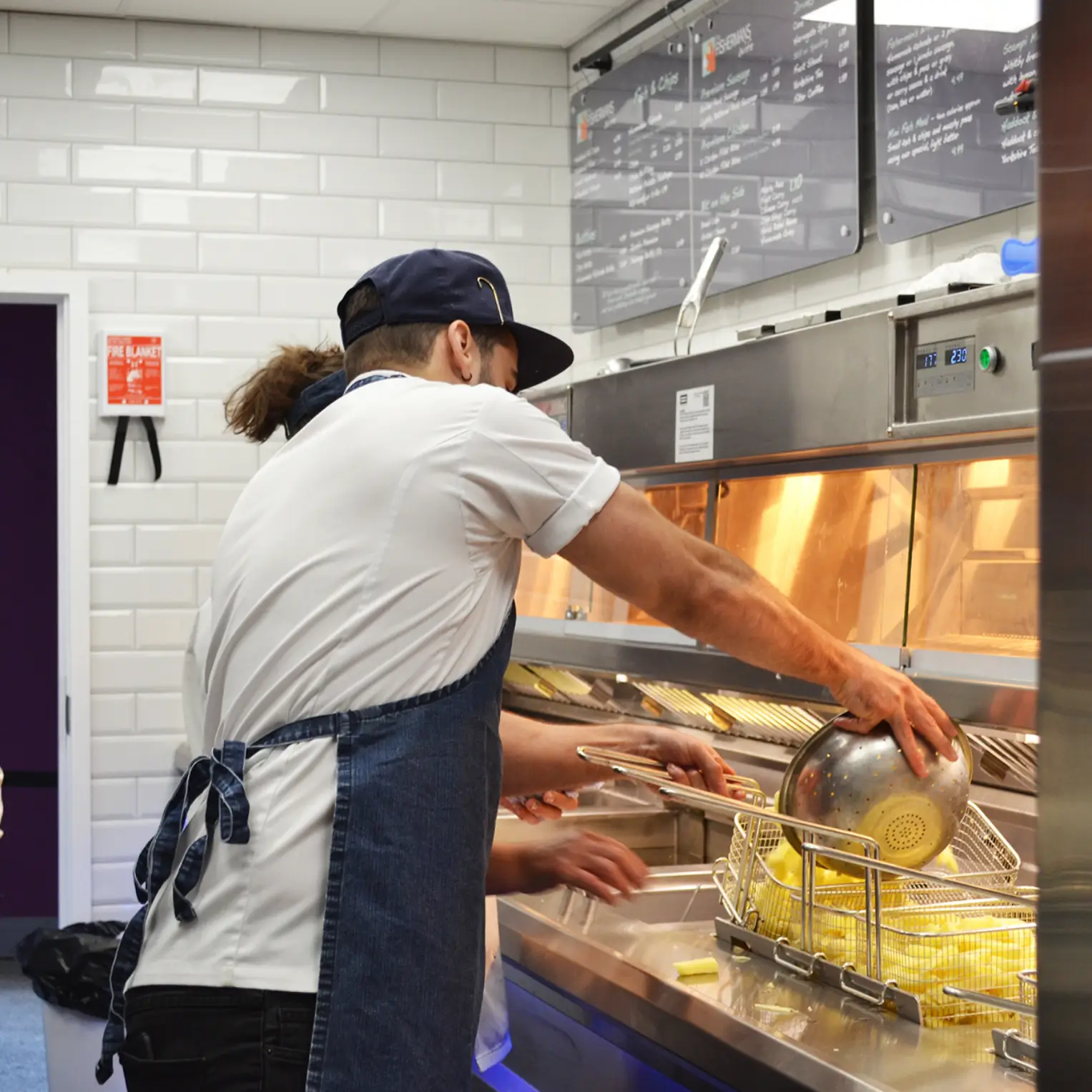 Chefs pouring chips into fryer