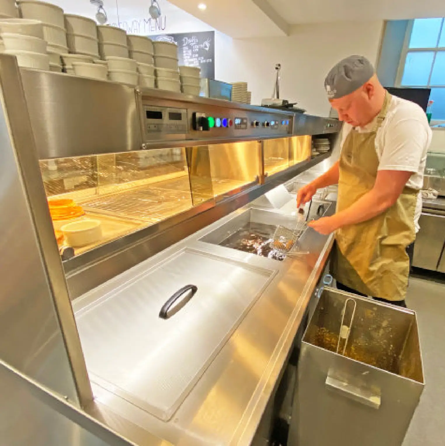 Man in kitchen frying fish