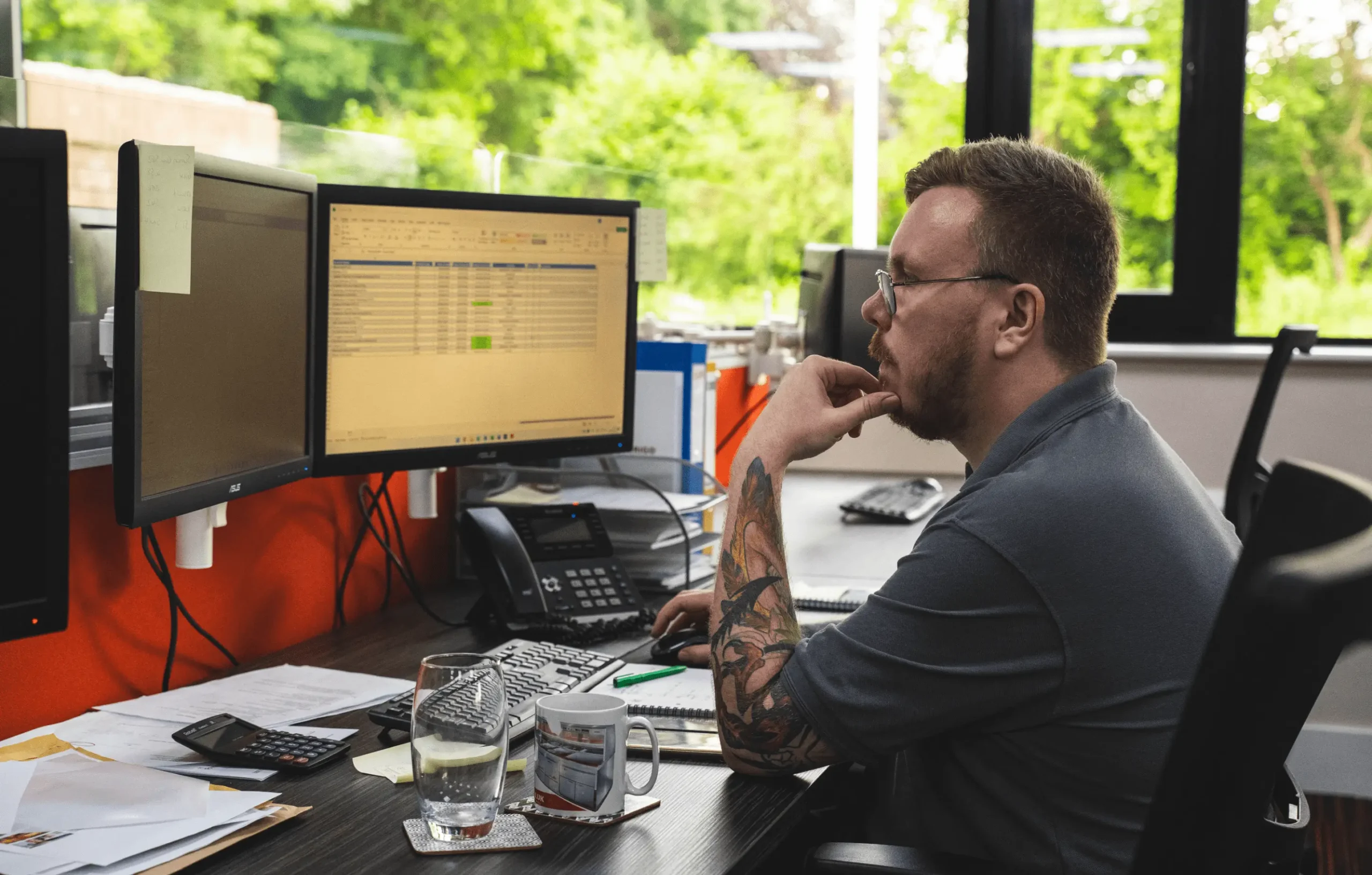 Man in office with two computer screens