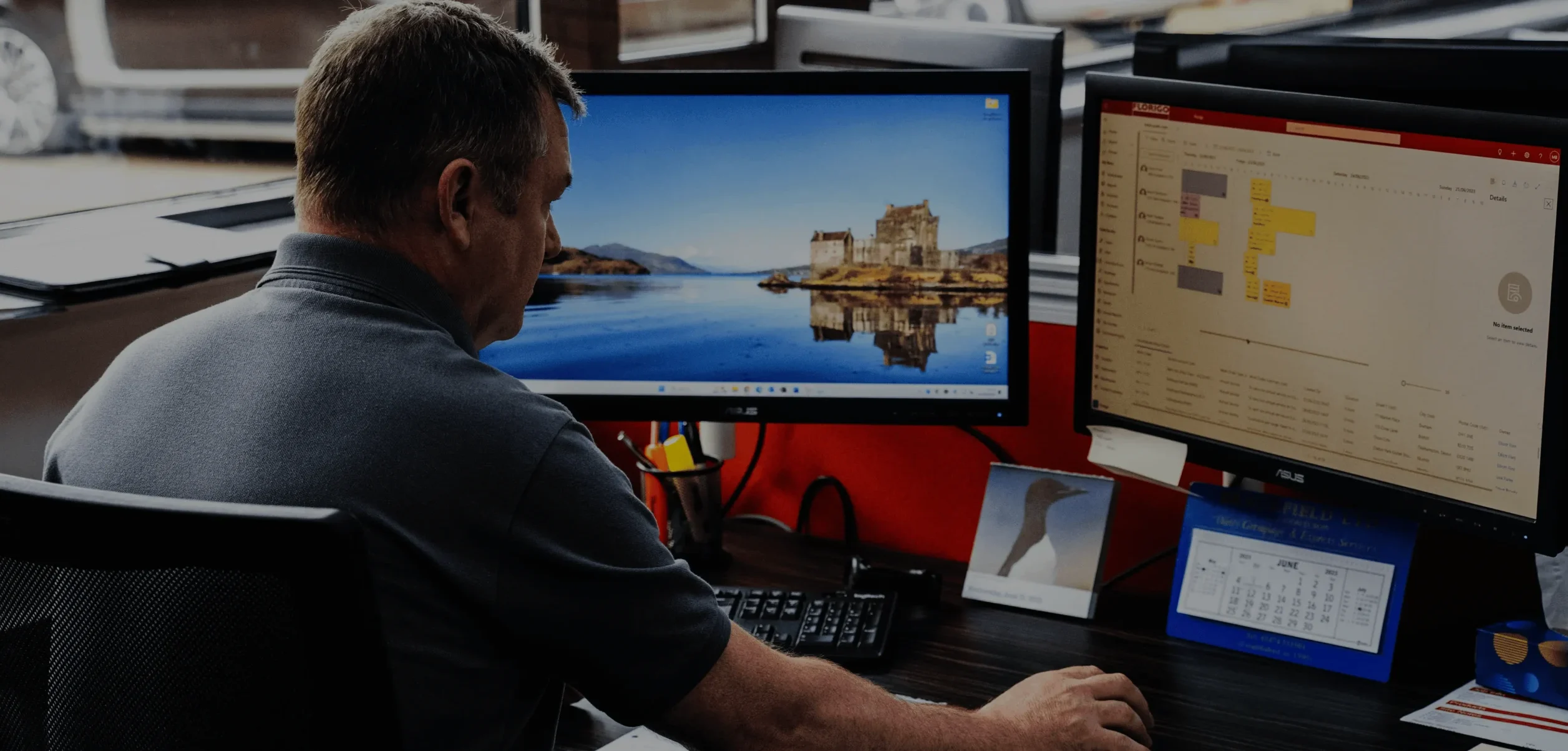 Man sitting at his desk with two computer screens