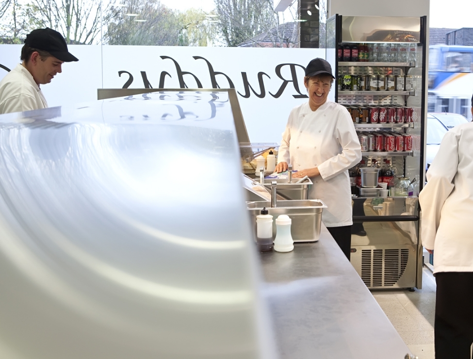 Image of woman smiling while serving fish and chips