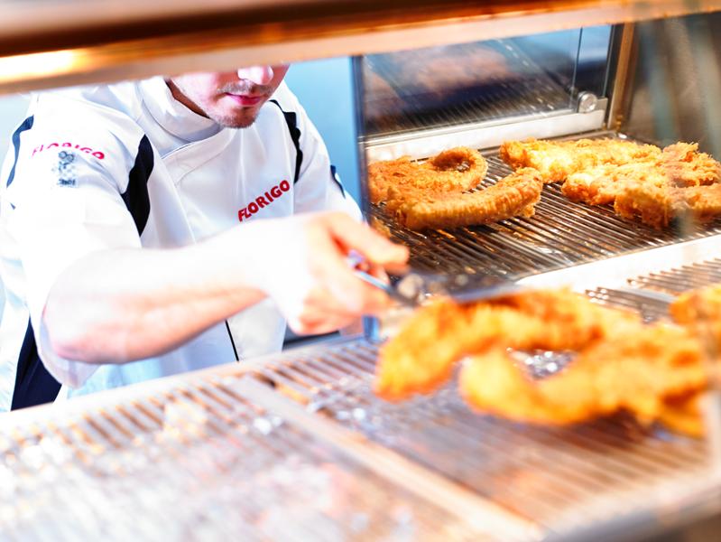 Image of man in Florigo chef white's grabbing fish out of the fryer