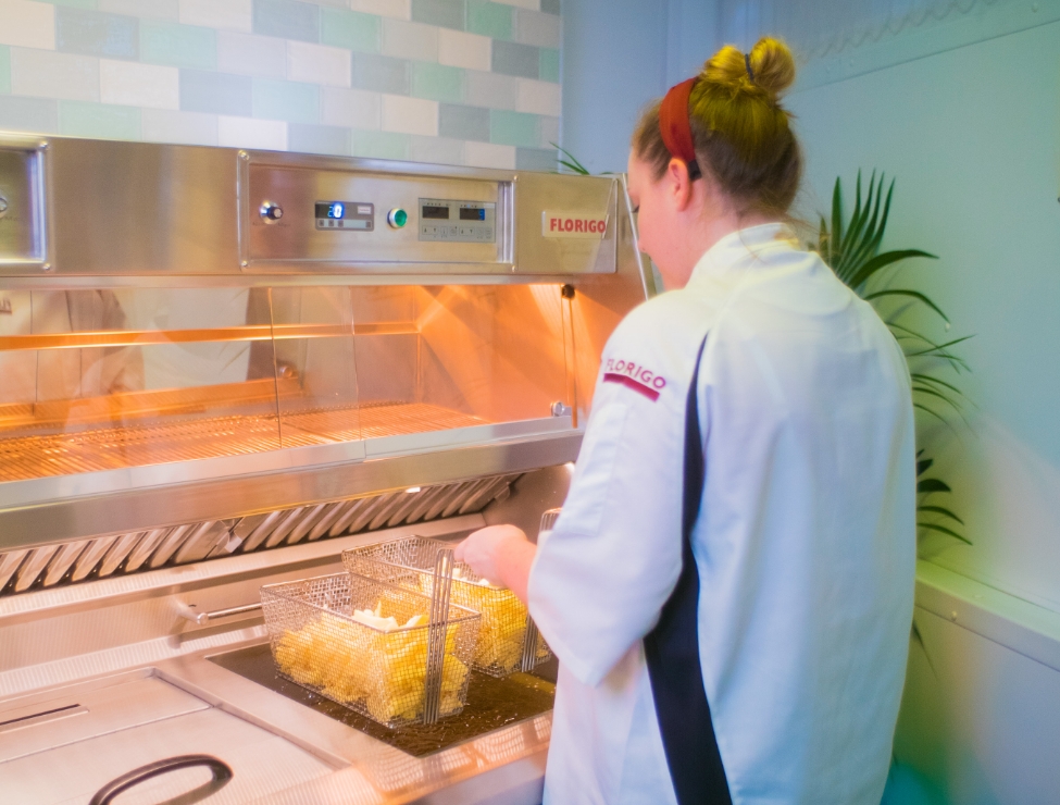 Woman wearing Florigo chef uniform while frying chips